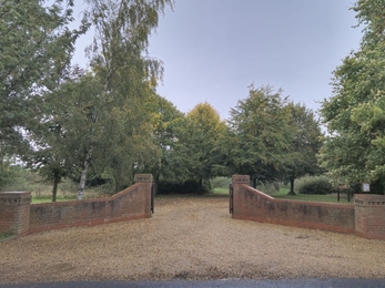 Muchwood Burial Site Entrance 2024, beautiful green trees surrounding the brick entrance