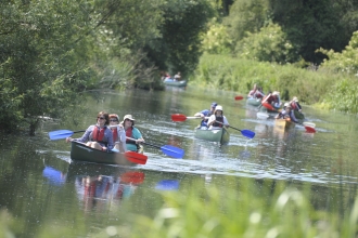 A group of people set off on canoes on the river Nene