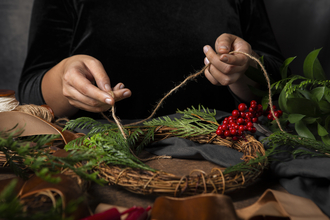 Hands working on making a willow wreath 