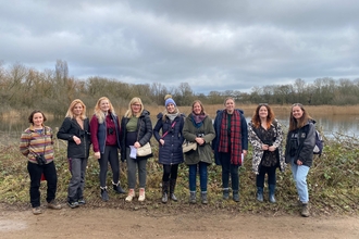 Group of girls standing next to a lake