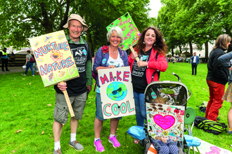 Wildlife Trust staff and child in pushchair attending climate change rally in London