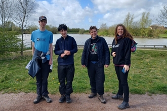 2 members of the Young Peoples Forum, a Wildlife Trust staff member and Dr Nik Johnson standing outside, smiling toward the camera