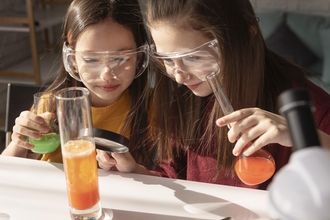 2 girls holding science equipment