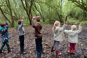 Children with sticks in Oaks Wood Cambourne Nature Reserve by Rebecca Neal