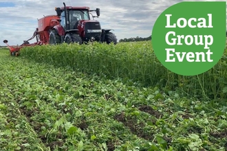 Harvesting machinery in a green field. Local Group Event icon overlaid.