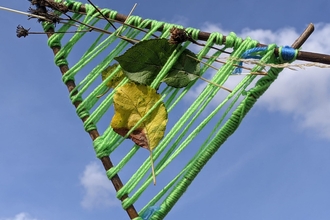 natural weaving held against a blue sky by Rebecca Neal