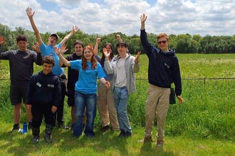 Young People's Forum smiling towards the camera and waving arms