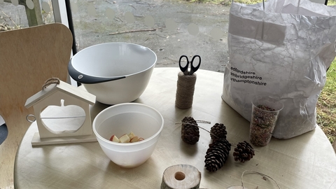 Image of table with items to make bird feeders