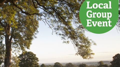 Lush green tree in the foreground with a vast countryside landscape in the background, "local group event" icon overlaid