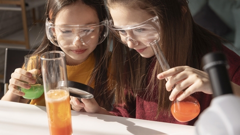 2 girls holding science equipment
