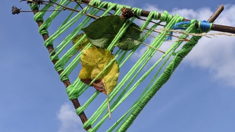 natural weaving held against a blue sky by Rebecca Neal