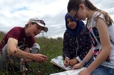 Two youth rangers surveying a grass habitat with a Wildlife Trust BCN staff member