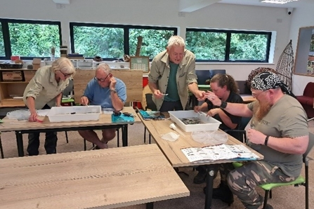 5 people sat in a classroom session examining findings from the river