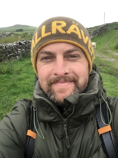 Rev'd Chad Chadwick selfie, smiling at the camera whilst on a hilly walk