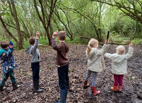 Children with sticks in Oaks Wood Cambourne Nature Reserve by Rebecca Neal